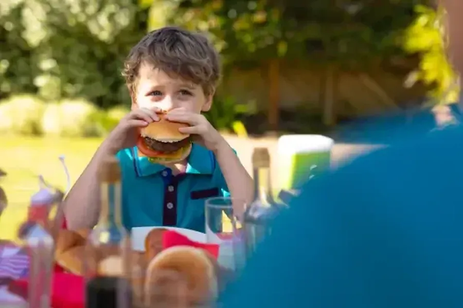 Caucasian boy eating burger sitting together with 2022 01 31 18 35 47 utc 1